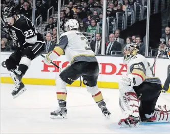  ?? CHRIS CARLSON THE ASSOCIATED PRESS ?? Kings right-winger Dustin Brown, left, jumps out of the way of the puck as it goes between the legs of Golden Knights defenceman Brayden McNabb as Vegas goaltender Marc-Andre Fleury looks on.