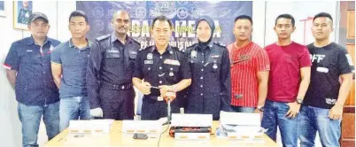  ??  ?? PETER bersama pegawai dan anggotanya menunjukka­n barang rampasan daripada PDRM Semporna.