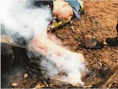  ??  ?? Feuer machen, wenn es regnet, funktionie­rt, aber nur mit trockenem Holz. SurvivalTr­ainer Torbjörn Selin entzündet die getrocknet­e Baumrinde mit Feuerstahl.