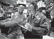  ?? RICHARD DREW/AP ?? Specialist Meric Greenbaum, left, and trader Steven Kaplan work on the floor of the New York Stock Exchange.