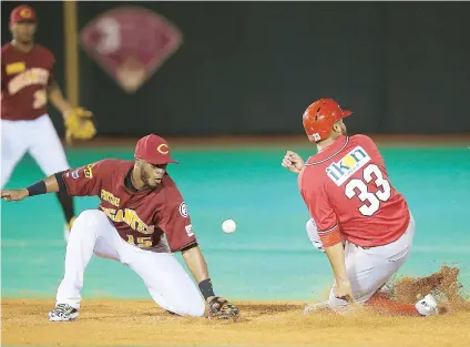  ??  ?? Roberto Peña se roba una base cuando el intermedis­ta Irving Falú no puede retener el tiro.