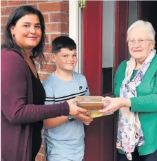  ??  ?? Special delivery Jeanette Oliver receives a hearty meal from Diane Colquhoun and son Clavin, 11.