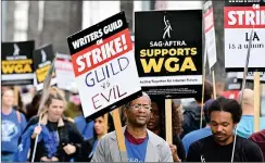  ?? ?? Writers and their allies walk a picket line.