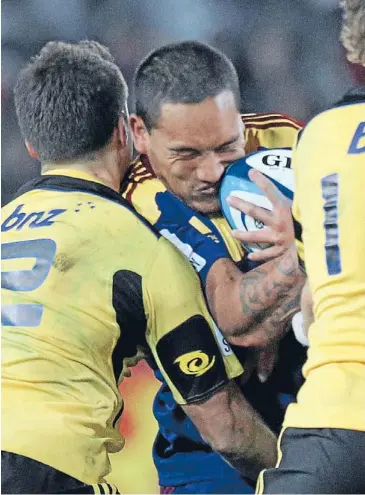  ??  ?? Creating pressure: Highlander Hosea Gear, centre, is tackled by Hurricanes Tim Bateman, left, and Beauden Barrett at Forsyth Barr Stadium, Dunedin, on Saturday night. Photo: Robyn Edie/fairfax NZ