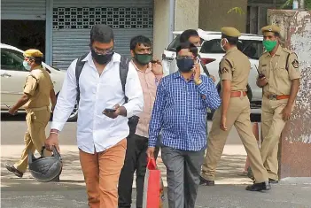  ?? — P. SURENDRA ?? People leave Telangana Secretaria­t, BRK Bhavan, on Monday after suspected Covid-19 positive cases were reported on the eighth floor of the building.