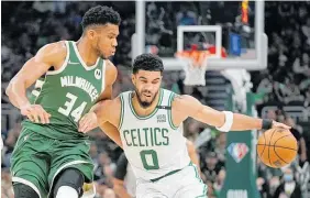  ?? Photo / AP ?? Jayson Tatum (right) holds off Giannis Antetokoun­mpo.