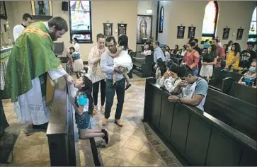  ?? Robert Gauthier Los Angeles Times ?? SEATS are wiped, and the Rev. Kristopher Cowles has hand sanitizer in case he touches someone’s mouth as they receive Communion. “We have to respect those who want to come in,” he said. “And those who don’t.”