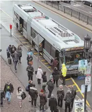  ?? STAFF PHOTO BY MATT STONE ?? SUBSTITUTE SERVICE: Passengers wait to board a bus above ground at a Silver Line stop. The line’s tunnel was closed because of concrete falling onto a station platform.