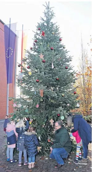  ?? FOTO: MARKUS RICK ?? Der Weihnachts­wunschbaum ist der größte in der Stadt. Eröffnet wurde die Aktion von Bürgermeis­ter Marc Venten mit Kindern der Kita Am Sportplatz. Noch warten 60 Wünsche auf Erfüllung.