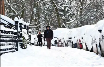  ?? ANDY BUCHANAN/AFP ?? Commuters walk to work on empty streets in Glasgow yesterday following heavy snowfall.