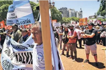  ??  ?? ► Manifestan­tes sostienen pancartas y banderas argentinas en el segundo paro general contra el gobierno de Macri, en diciembre de 2017, en Buenos Aires.