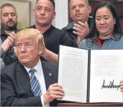  ?? Picture: AP ?? Donald Trump signs into law new tariffs on the import into the US of steel and aluminum.