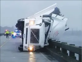  ?? Tyrrell County Sheriff’s Office ?? HIGH WINDS tipped over an 18-wheeler on the U.S. 64 bridge in North Carolina, killing its driver. In Florida, a homeless man was killed by a falling tree.