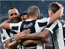  ??  ?? Juventus’ Gonzalo Higuain (centre) celebrates with team mates after scoring against Chievo in their Italian League match at the Allianz Stadium in Turin. —