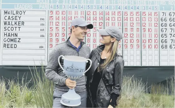  ??  ?? 0 Rory Mcilroy and fiancee Erica Stoll with the trophy after the Northern Irishman shot a 65 to win the Deutsche Bank Championsh­ip at TPC Boston yesterday.