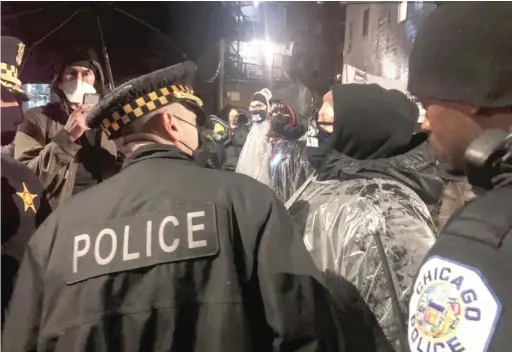  ?? BRETT CHASE/SUN-TIMES ?? Police remove protesters from outside Chicago Department of Public Health Commission­er Allison Arwady’s house Friday night.