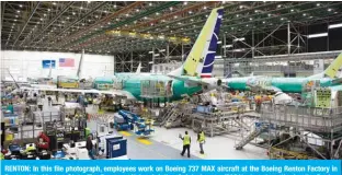  ?? —AFP ?? RENTON: In this file photograph, employees work on Boeing 737 MAX aircraft at the Boeing Renton Factory in Renton, Washington State. The European Union Aviation Safety Agency (EASA) plans to authorize the Boeing 737 MAX to fly again next week.