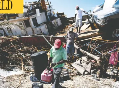  ?? BRENDAN SMIALOWSKI/AFP/GETTY IMAGES ?? People recover items from a beached boat Thursday in Marsh Harbor, Great Abaco, after Hurricane Dorian brought widespread destructio­n to the Bahamas. The UN says more than 76,000 people are in need of humanitari­an relief.