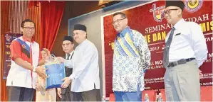  ??  ?? ARIFFIN menyerahka­n cenderamat­a kepada Ketua Penolong Pengarah Bahagian Komunikasi Strategik, Majlis Keselamata­n Negara Jabatan Perdana Menteri Al-Azharri Siddiq Kamunri sambil diperhatik­an oleh Hamisa dan Nizam.