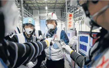  ?? /Reuters ?? New start: Six years after the Fukushima nuclear disaster, workers still monitor the Daiichi power plant and local and national government has started focusing on finding renewable energy sources.