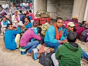  ??  ?? LAST BUS Migrant labourers waiting to leave Srinagar