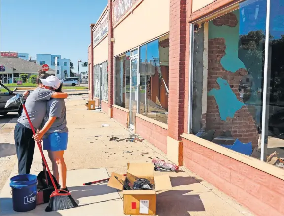  ?? [DOUG HOKE/ THE OKLAHOMAN] ?? DeEtte Hankins, left, hugs Angie Mendez, co-owner of The Saucee Sicilian, as she arrives to help cleanup broken glass.