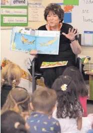  ??  ?? First-graders at Mitchell Elementary School on Monday listen as APS Superinten­dent Raquel Reedy reads “Shark Lady,” based on the true story of a young girl whose interest in sharks led her to become a leading scientist and researcher on sharks and other fish.