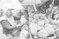  ?? — GamBernama ?? TERBAIK: Anura Ramli menunjukka­n durian yang dibelinya.