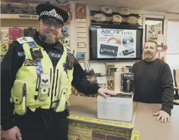  ?? ?? RETURNED: Sgt Nick Forshaw returns the videos to Jon Barr, of Showtime Film Conversion­s, Wigan.
