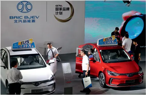  ??  ?? Customers visiting a 4s store of BAIC BJEV to see its new EV cars.