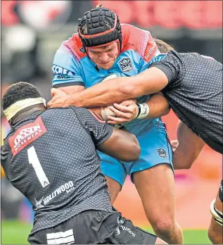  ?? ?? Glasgow’s George Turner is stopped in his tracks by a couple of Sharks in Durban yesterday