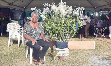  ??  ?? Catherine Thomas poses with her winning Dendrobium JaqHawaii orchid at the Montego Bay Orchild Society Show recently.