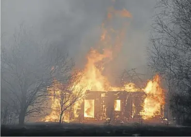  ?? REUTERS / VOLODYMYR SHUVAYEV ?? Una casa de madera en llamas, cerca de Chernóbil.