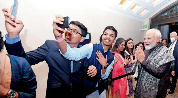  ?? ?? People from the Indian community click a selfie with Prime Minister Narendra Modi as they welcome him on his arrival in Berlin on Monday. — ani