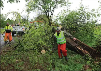  ?? (Arkansas Democrat-Gazette/Colin Murphey) ?? Pulaski County workers clean up downed trees and limbs on Craig Road near Scott on Tuesday after a microburst with strong winds struck the area late Monday.