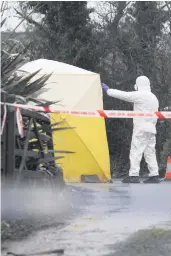  ??  ?? Richard Miskelly, and a forensic officer at the scene of his killing in Newtownard­s, Co Down