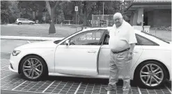  ?? THE PEW CHARITABLE TRUSTS/TNS ?? John Robinson of Mobile, Ala., parks his car on a solar road surface in front of a “solar tree” at the West Point, Ga., visitors center on Interstate 85. New technologi­es for green, sustainabl­e highways are being tested near the Georgia-Alabama border.