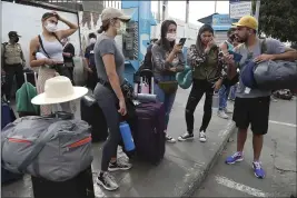  ?? MARTIN MEJIA — THE ASSOCIATED PRESS ?? Tourists from the United States wait outside the closed Jorge Chavez Internatio­nal Airport in Callao, Peru, Friday, for a member of the U.S. Embassy to escort them to a plane that will fly them back to the U.S.