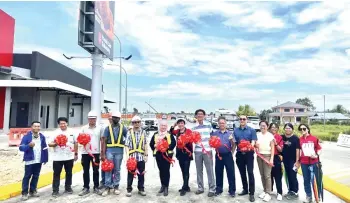  ?? ?? Susan (eighth right), Haliza (sixth left) and others officiate the opening of the Pan Borneo Highway-Parklane City road at its entrance near McDonald’s drive thru.