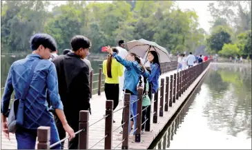  ?? HONG MENEA ?? Tourists on the bridge to Neak Pean temple, on the northern boundary of Siem Reap town in January.