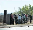  ??  ?? ANGERED: Bekkersdal residents take cover after clashing with police yesterday morning.