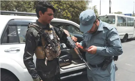  ?? AP ?? An Afghan policeman checks the documentat­ion of a gun owner, at a temporary checkpoint in Kabul on Sunday. All foreign troops are to withdraw from Afghanista­n.