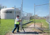  ?? ANTONIO PEREZ/CHICAGO TRIBUNE ?? An engineer from Robinson Engineerin­g closes the gate to the pumping station after checking gauges in Dixmoor.