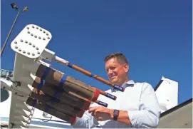  ?? DAVE KOLPACK/AP ?? Neil Brackin, president of Weather Modificati­on Inc., a North Dakota company that conducts cloud-seeding operations, checks seeding flares installed on the wings of one of the planes outside the company’s hangar in Fargo, N.D.