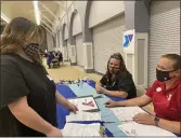  ?? KYRA GOTTESMAN — MERCURY-REGISTER ?? Kaitlyn Rigsbay, left, a junior in Oroville High School’s Independen­t Study Program, schedules her interview time with Oroville YMCA staff members Breann Hastain and Sara Pierce at the Youth Job Fair on Tuesday in Oroville.