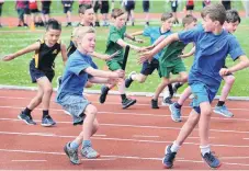  ??  ?? Jimmy Hinds passes the baton to Reuben Ure (both 9) for the Macandrew Bay School team in the boys under10 relay.