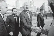  ??  ?? General Electric CEO Jeff Immelt, center, greets constructi­on workers Monday after a ceremonial groundbrea­king at the site of GE’s new headquarte­rs in Boston.