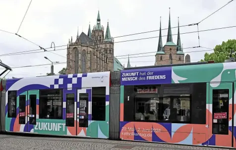  ?? MARTIN SCHUTT / DPA IMAGES ?? Eine Straßenbah­n am Domplatz wirbt für den Katholiken­tag, der vom 29. Mai bis zum 2. Juni in Erfurt stattfinde­t.