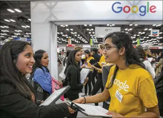  ?? RALPH BARRERA / AMERICAN-STATESMAN ?? Akanksha Pathak, a college student from East Brunswick, N.J., talks with Google Representa­tive Srialekhya Jonnalaged­da on Thursday at the job fair of the Society of Women Engineers in Austin. About 300 employers are participat­ing in the fair which also...
