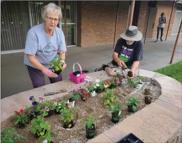  ?? SARA WAITE — JOURNAL-ADVOCATE ?? Volunteers from the Heritage Center plant flowers and vegetables in the new raised garden beds June 1, 2021.